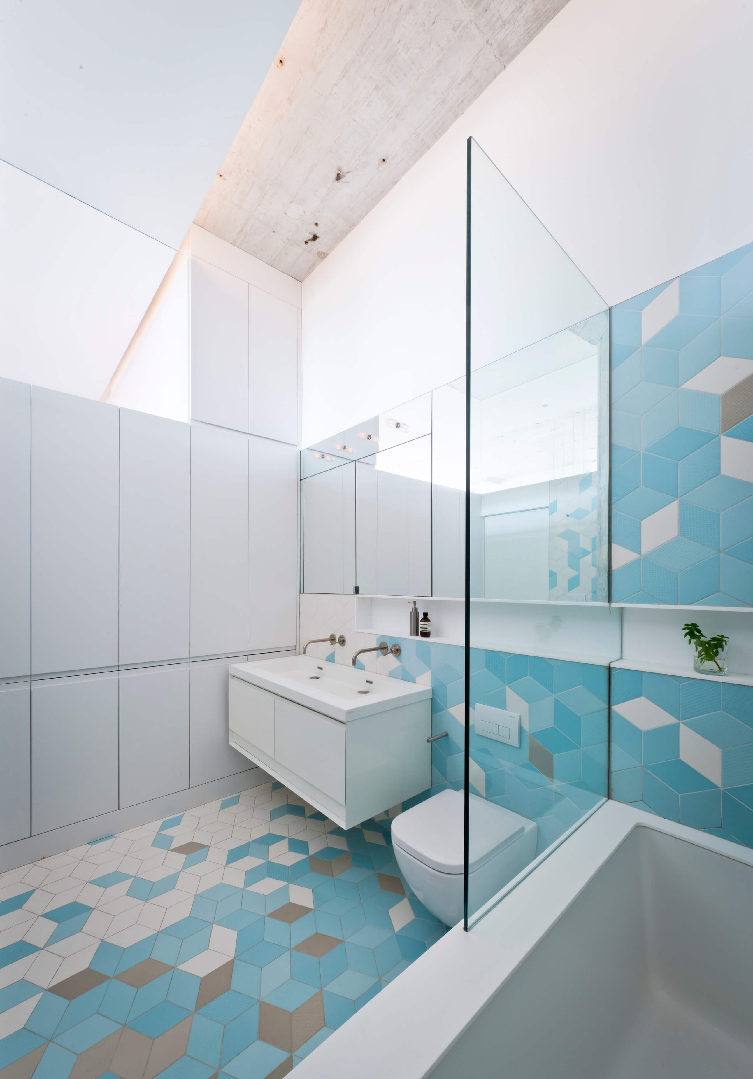 Bathroom with blue geometric tiles and white cabinets
