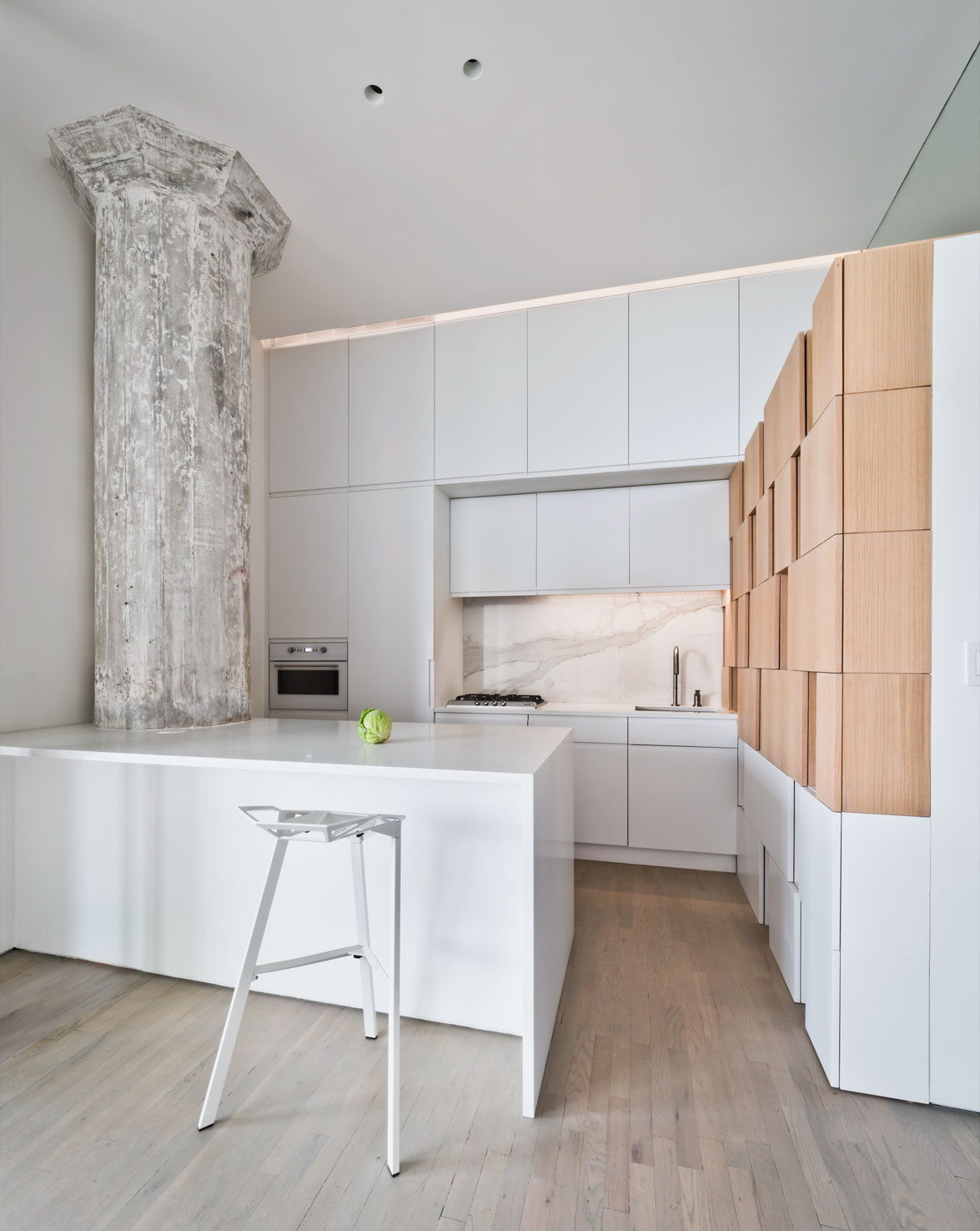 Modern minimalist kitchen with white cabinets and wood accents