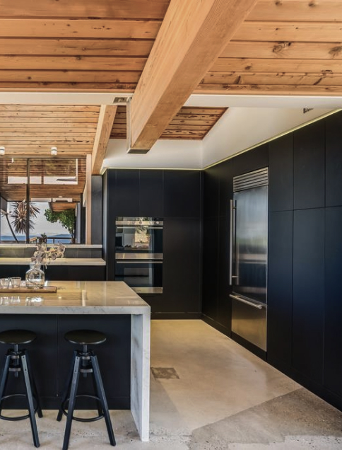 Modern kitchen with marble island dark cabinets and wood ceiling